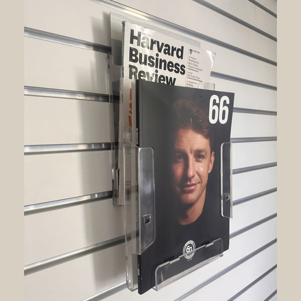 Magazine stand with 'Harvard Business Review' magazine on a slat wall.