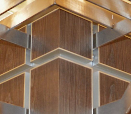 A close up of Stickman MCLNCAP aluminium capping profiles and walnut MDF panels used in a cabinet design 