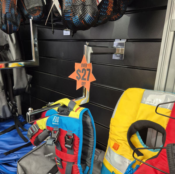 Life vests and safety equipment on a cranked arm bracket rack with a discount sign in the background.