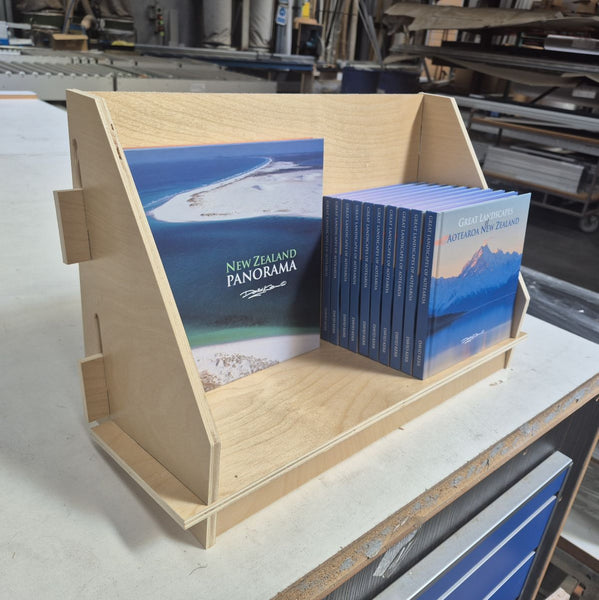 custom made wooden display stand with New Zealand Panorama books in a workshop setting
