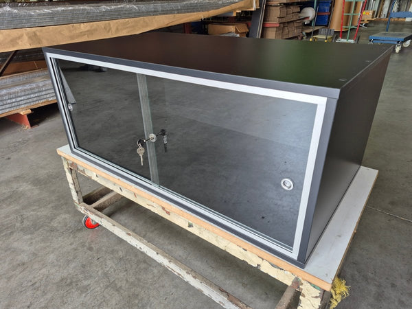 lockable wooden cabinet with a glass front  in a factory setting