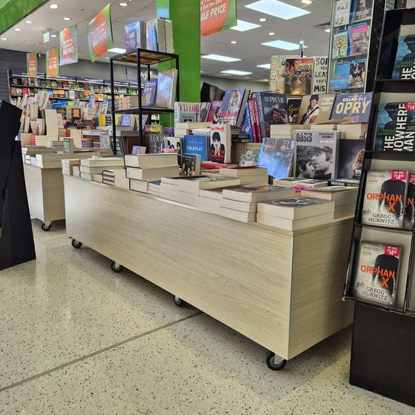 Book display area in a store with books on shelves and  display tables.