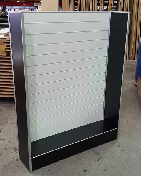 Plankwall free standing slatwall panel display stand in white and black in a factory setting