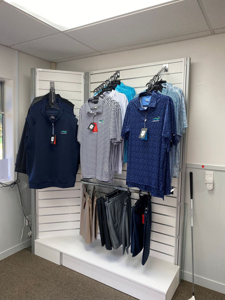 sports shirts on waterfall display arm brackets for sale on retail slatwall in Plankwall's modular display system