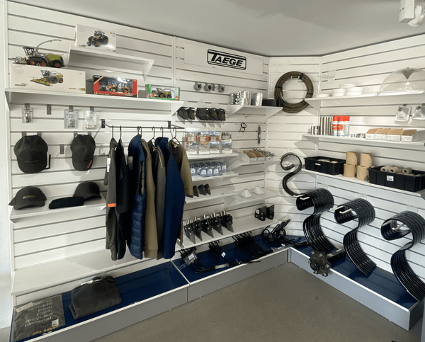 A set of freestanding slatwall panels with hidden storage display of automotive parts and accessories in a store with 'AEGE' branding