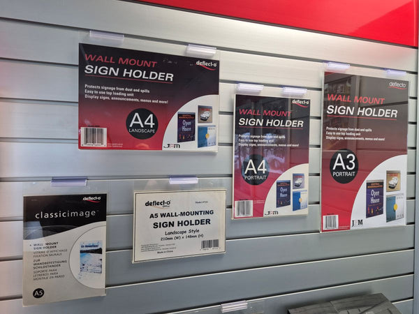 an assortment of wall mounted sign holders on slatwall 