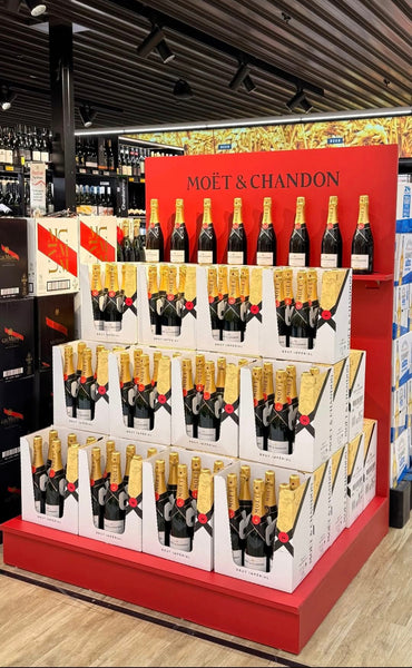 Custom Plankwall red floor display stand with champagne bottles and boxes in a supermarket