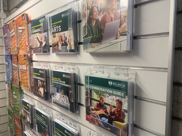 university brochures on wall mounted holders on slatwall grooved display panels