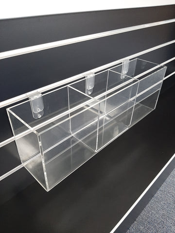 Clear acrylic display box with movable U-shape divider used for organising small items on retail counters, reception desks, and office displays.