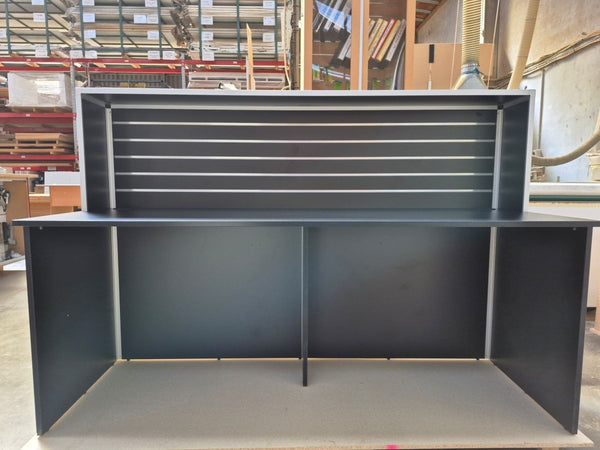 A Plankwall Reception Desk, 1800mm wide in Black shown front one in a factory setting