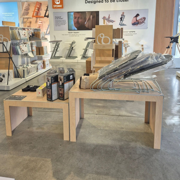 Nested tables for retail displays of floor stock in a premium ply finish merchandised with baby products in a retail store.