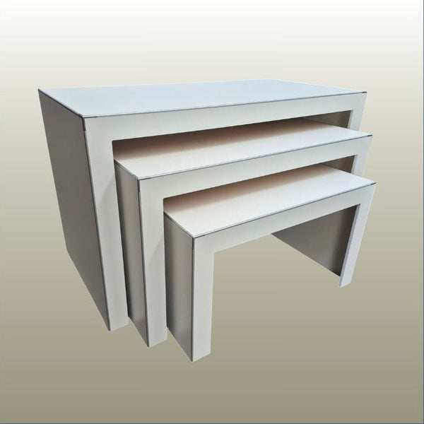 Set of three white nesting display tables on a beige background