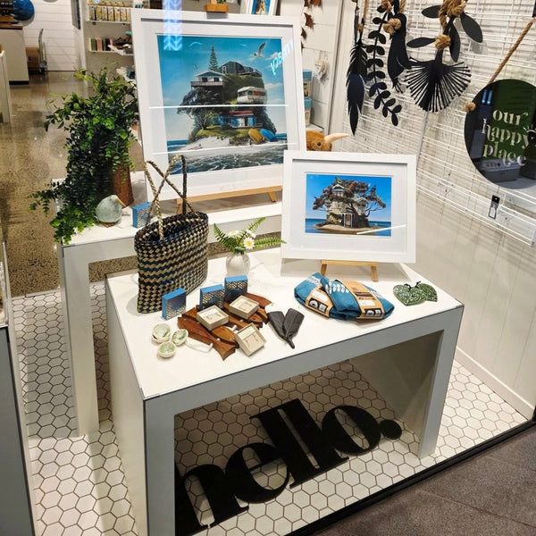 Plankwall white nesting display tables used in a front retail window displaying high end art and tourist souvenirs.