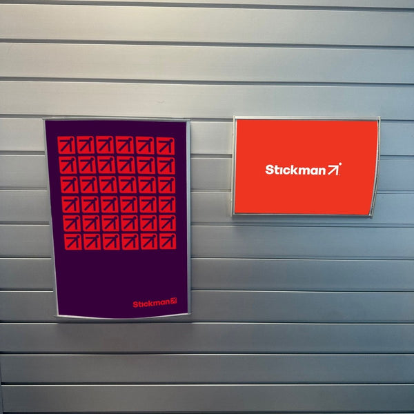 A3 and A4 Radius Poster Frames displayed on a Plankwall® slatwall retail wall.