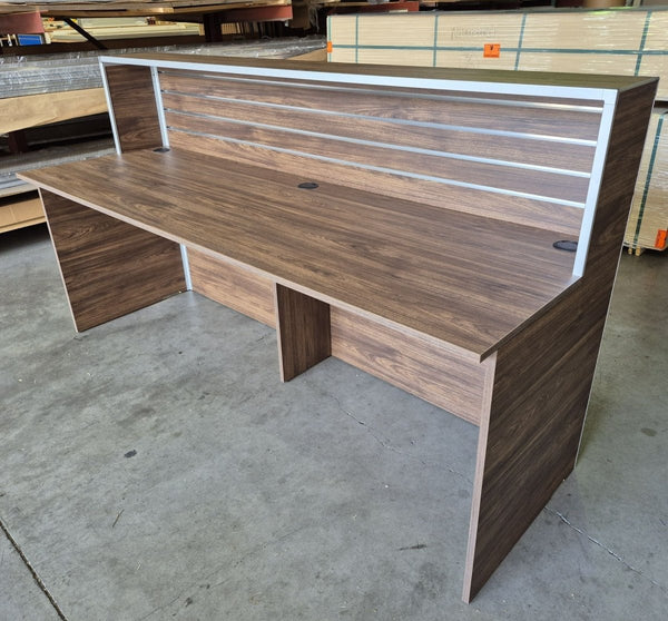 Plankwall wooden Reception Desk in walnut shown in a factory setting