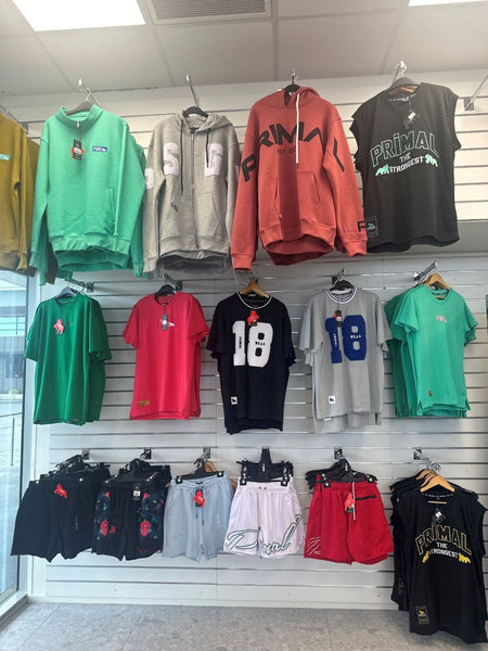 Garments hung on straight arm display brackets installed on Plankwall slatwall in a retail store.