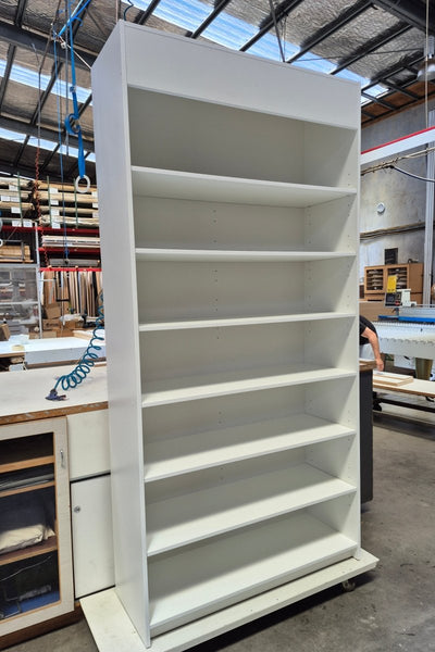 Large white Plankwall display cabinet with shelves in a warehouse setting