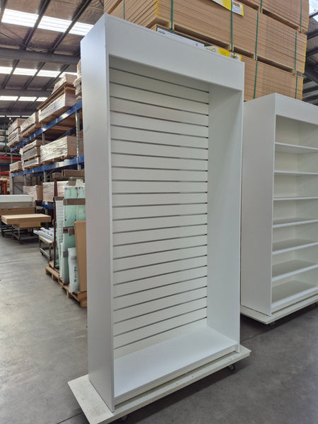 Large white Plankwall display cabinet with slatwall  grooves in a factory setting 