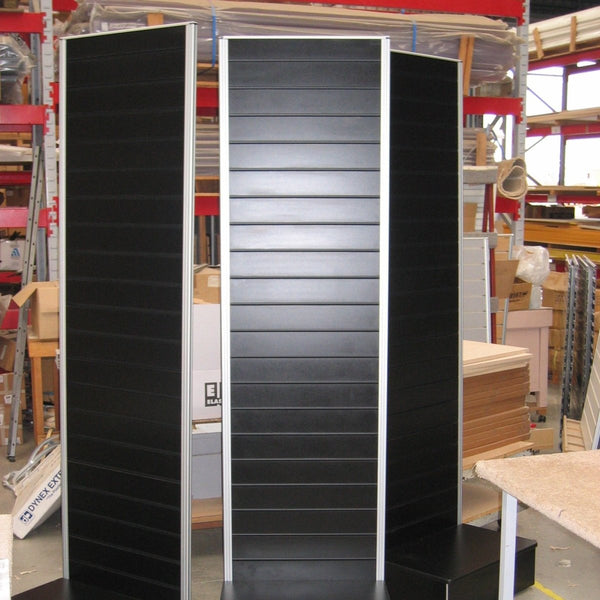 Black slatwall display stands in a warehouse setting