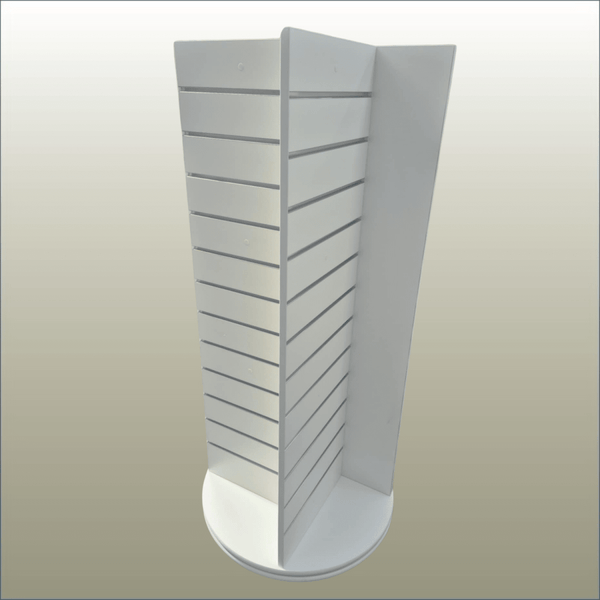 A white, free-standing four-sided display unit with slatwall panels on all sides, equipped with castor wheels for mobility.