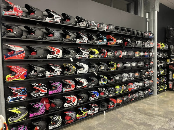 18mm black melamine shelves attached to black Plankwall slatwall panels displaying helmets in a retail setting.
