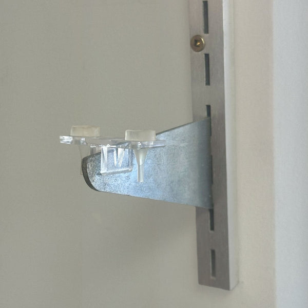 double bracket clip for shelf bracket featured here with rubber grommet on slotted wall channel to prevent glass shelf from slipping