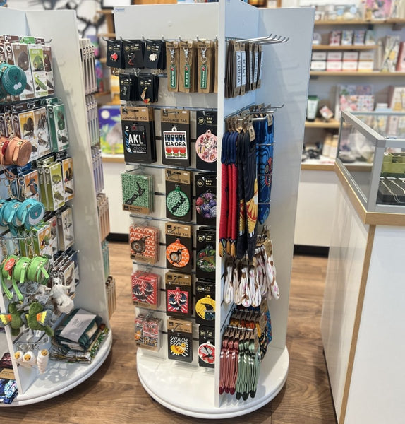 A Plankwall freestanding four-sided display unit with slatwall panels on all sides displaying retail items in a store