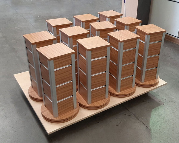 Plankwall Counter Top Retail Display stands with slatwall grooves in a wood finish on a pallet in a factory setting