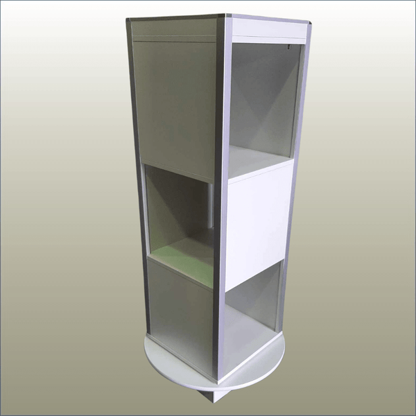 Three-level open rotating display stand tower with signage panels and product display sides in a retail environment.
