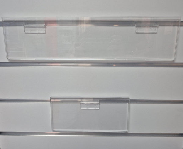 front view of clear acrylic slatwall header card sign holder installed on grey aluminium slatwall panel displaying retail header signage.