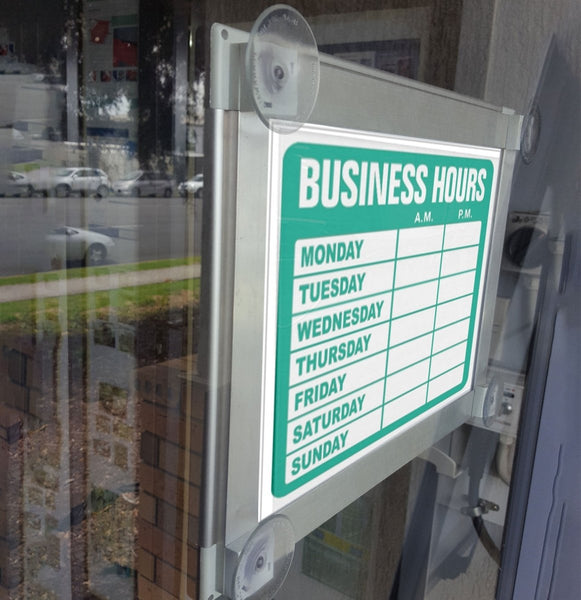 A Plankwall poster snap frame sign displayed, featuring suction cups for attachment to windows.