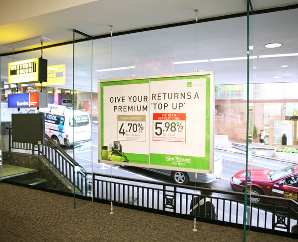 Promotional sign on a glass wall with car services displayed outside.