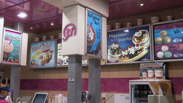 Ice cream shop interior with promotional signs displayed in Plankwall snap poster frames above the counter.