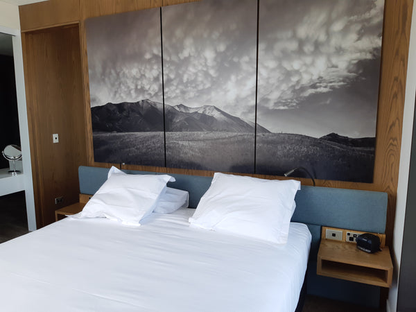Bedroom with a large mountain landscape painting on the wall