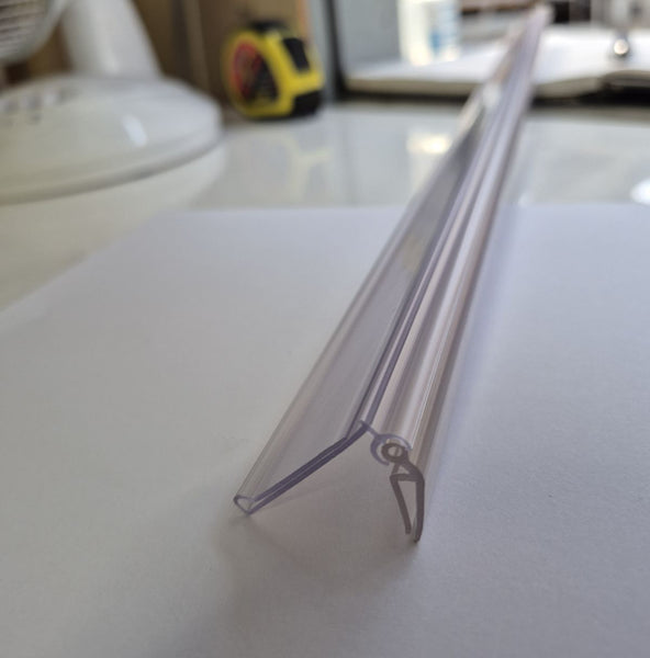 Clear plastic strip on a white surface with a blurred background