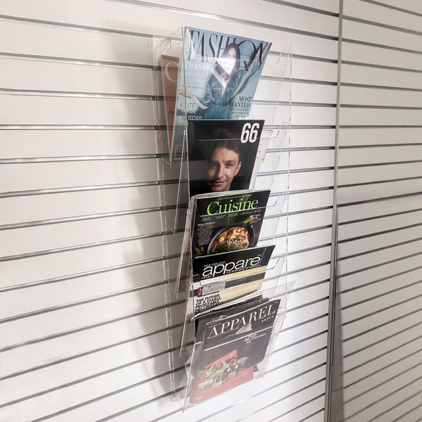 Magazine holder with various magazines on a slatted wall