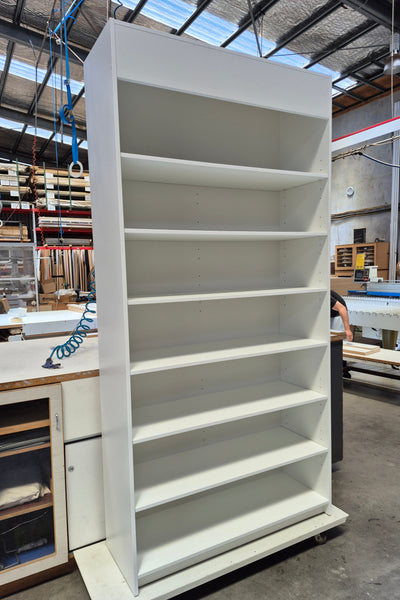 Large white Plankwall display cabinet with shelves in a warehouse setting