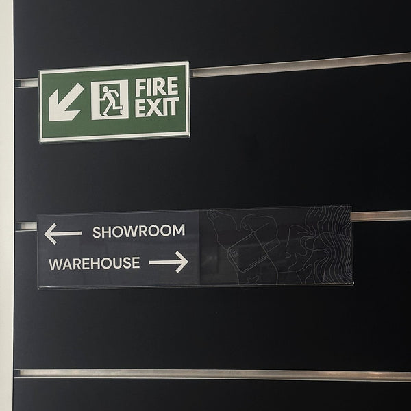 Fire exit sign and directional signs on a black wall
