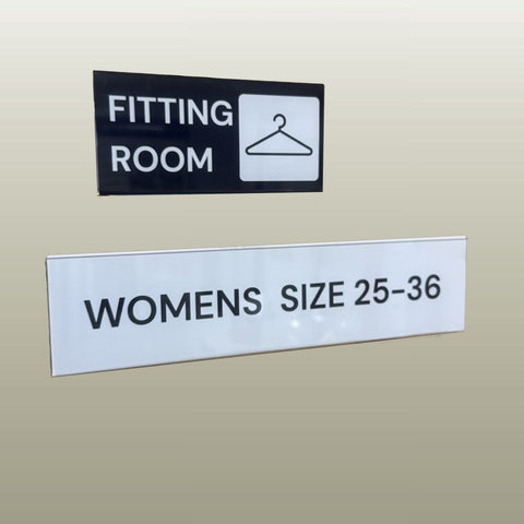 Fitting room sign with a hanger icon and text on a beige background