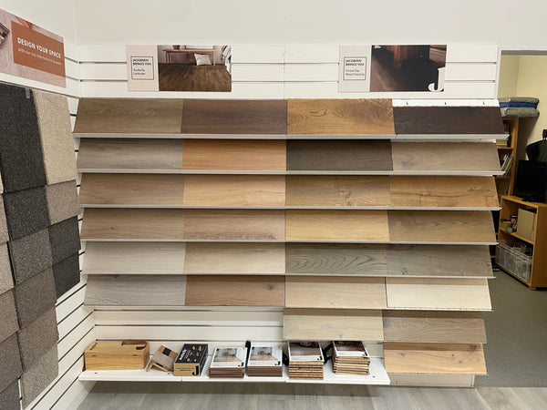 Front view of wood panel samples displayed on white sloping shelves attached to a white slatwall panel.