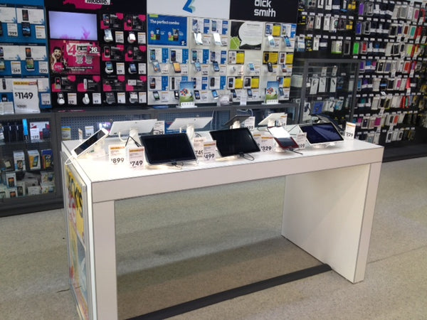 side view of a Plankwall electronics display table in white displaying tablets in a Dick Smith electronics retail store