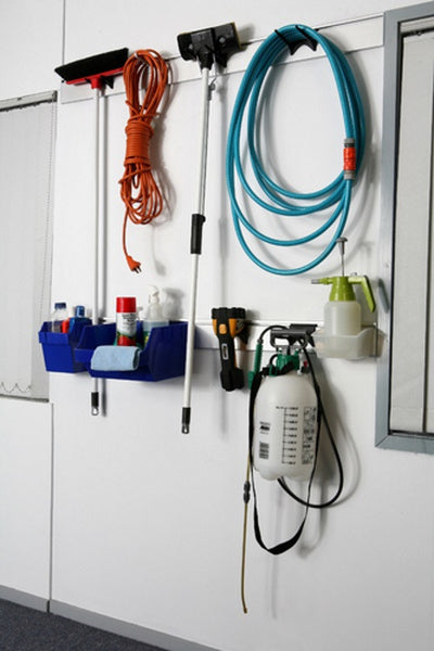 Utility plank used for wall storage of cleaning equipment in garage with 