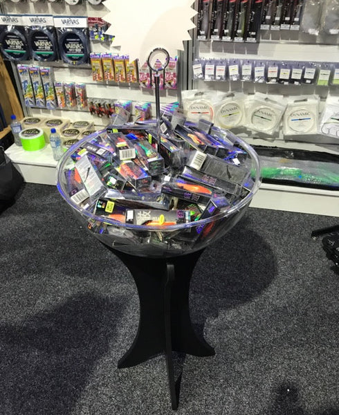 Plankwall clear Acrylic Fishbowl display stand with black legs shown with stock in store and attached signage