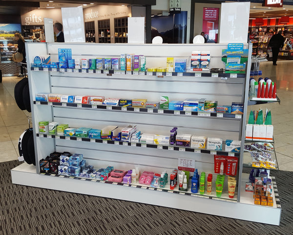 Plankwall Double Plinth G60 Gondola in white shown stocked with health products in an airport