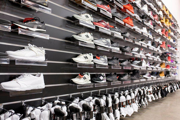 Plankwall clear acrylic shoe display shelves with sneakers on black slatwall