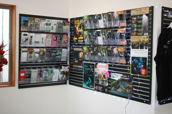 Calext mounted on black slatwall on a wall panel with brochures and fairy lights in a tourist bureau