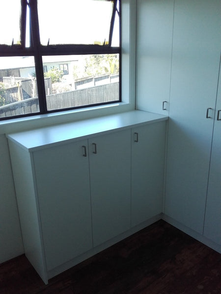 Custom white built in drawers in home by window