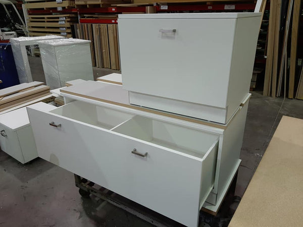 Custom cabinets in white shown stacked in factory. lockable