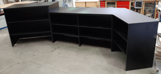 Custom large black retail counter with open shelves