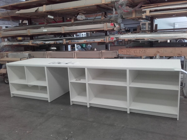 Custom large counter with open shelving in white in a factory